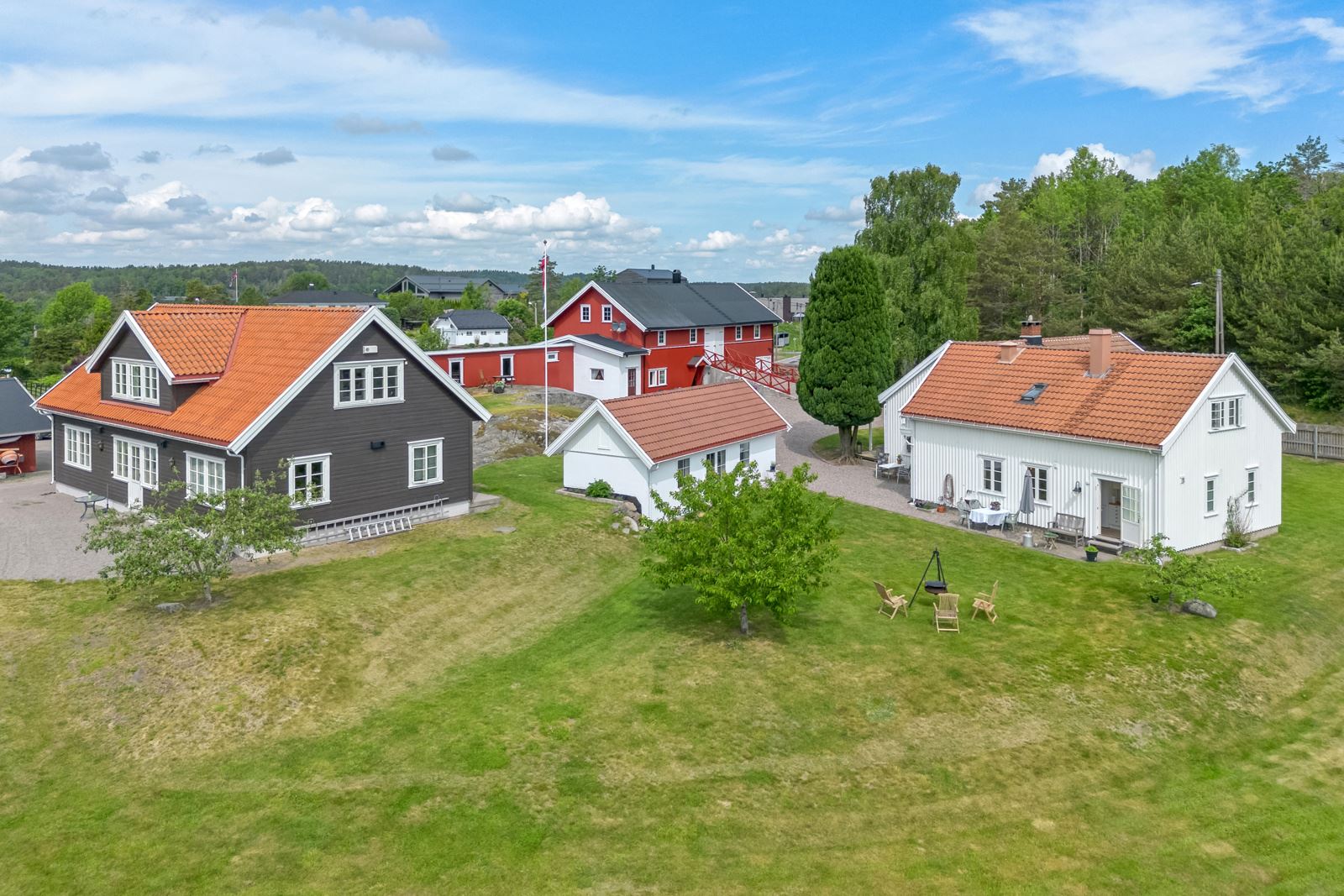 Et pent våningshus malt i hvitt utgjør hjertet på tunet. Leilighetsbygg fra 2015 med 4 godkjente leiligheter klare for utleie