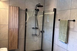 Badet er nyoppusset i 2024, med delikate fliser på både gulv og vegger. Ny baderomsinnredning ble satt inn, og speil med lyskant. Nytt dusjhjørne med glassvegger, og svart armatur og dusjhode. 
