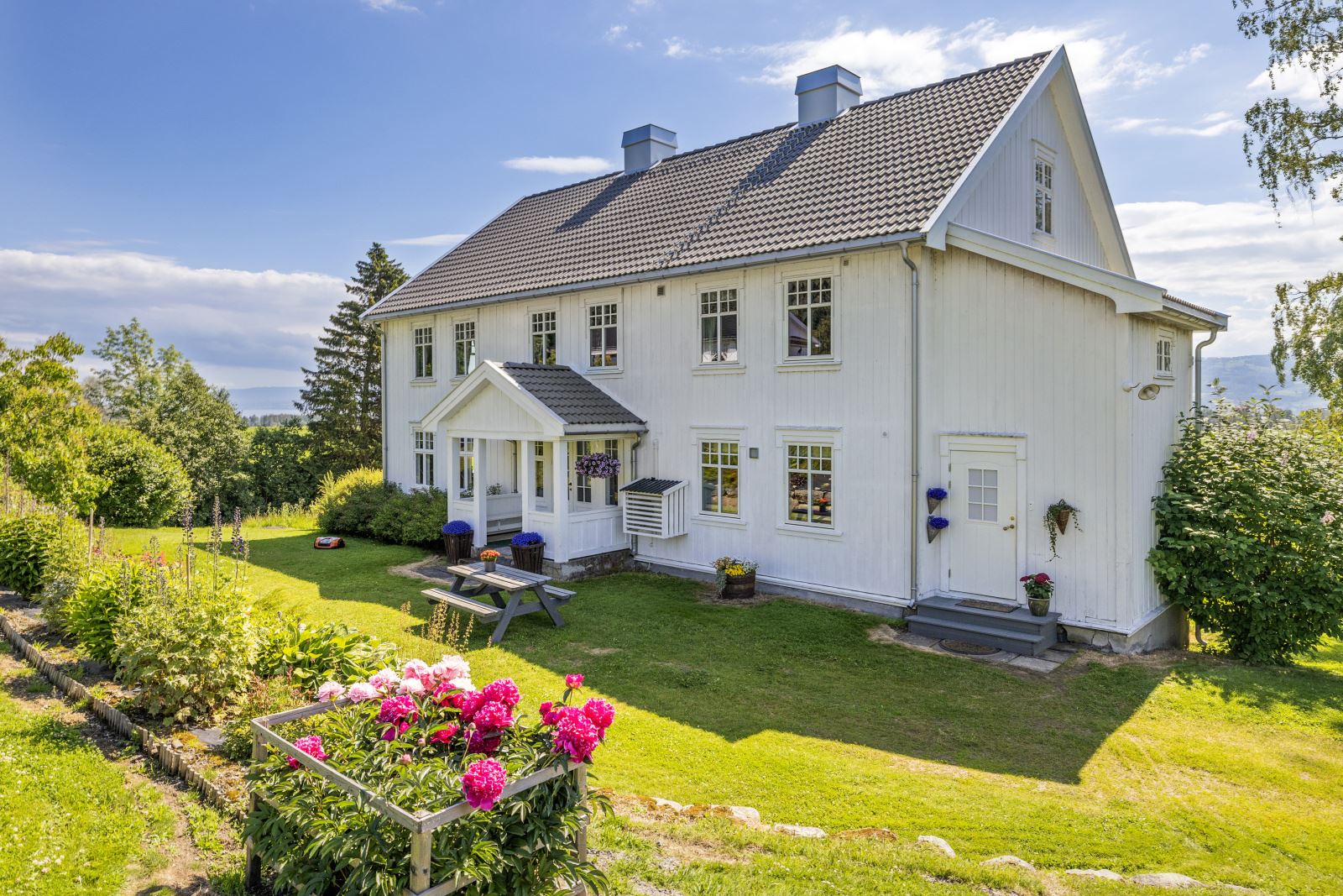 På baksiden av huset er det et overbygd hovedinngang og bi-inngang til kjøkkenet.