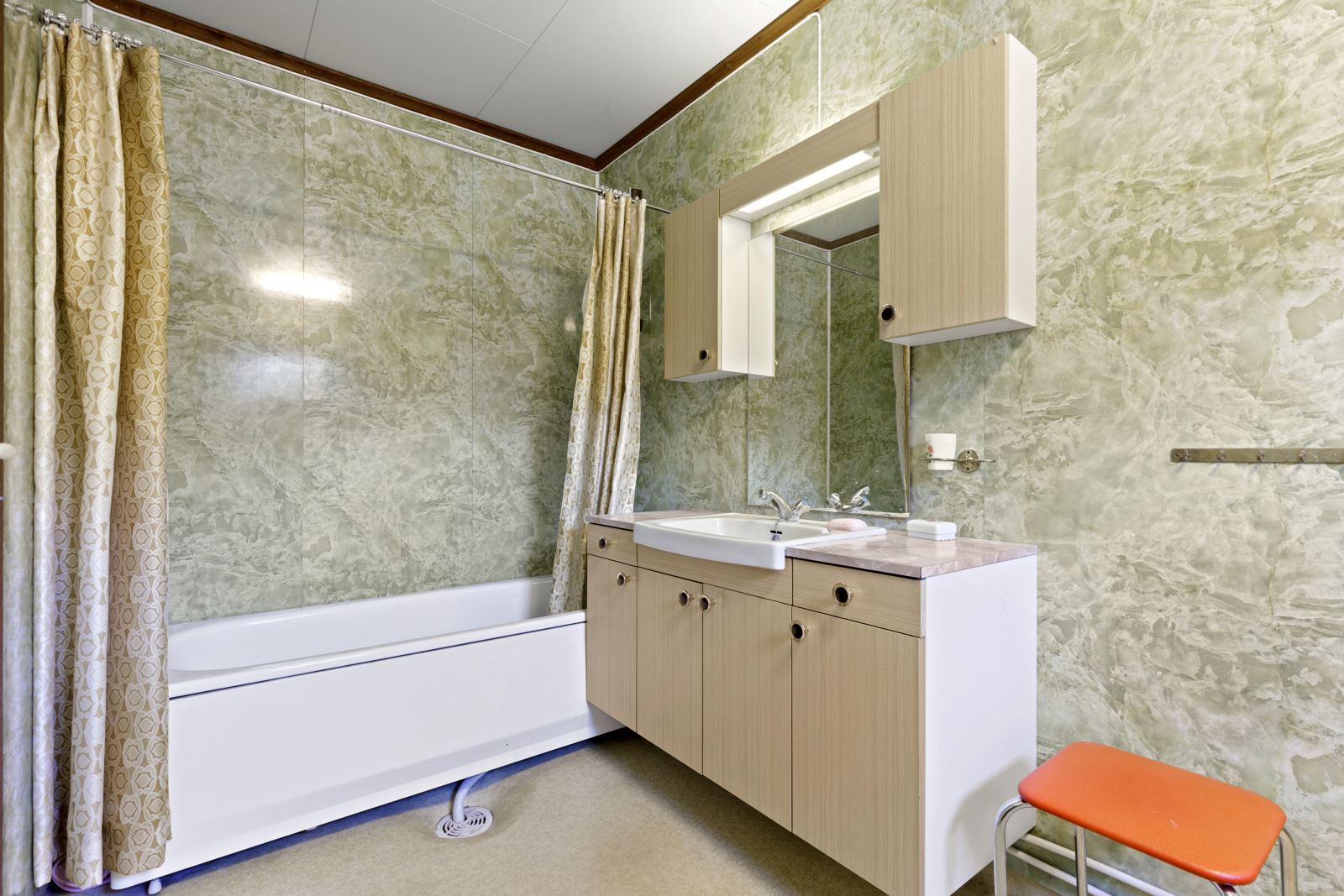 Bad med badekar/dusj, våtromsplater på vegg og belegg på gulv